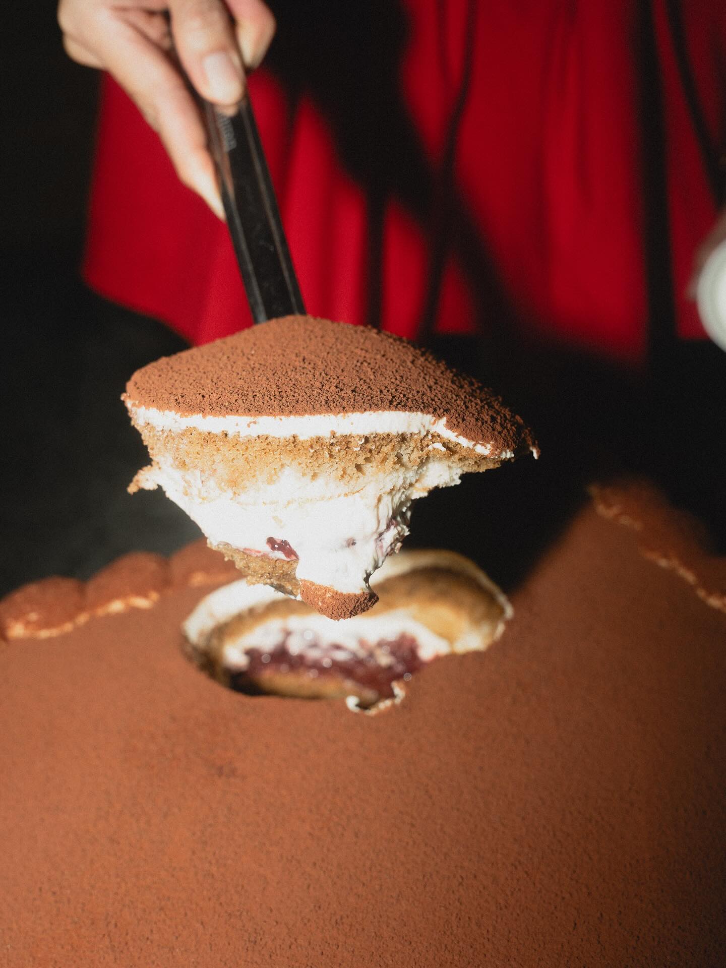 Cross-section of a giant cherrymisu being scooped, showing layers of mascarpone and cherry
